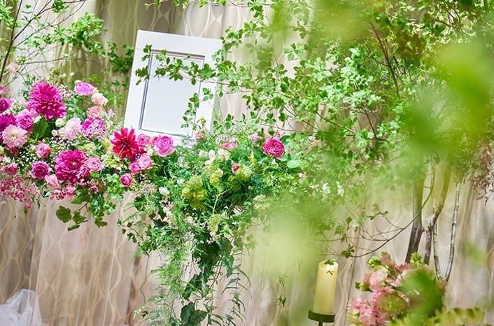 遺影写真の周りにたくさんの花が飾られています