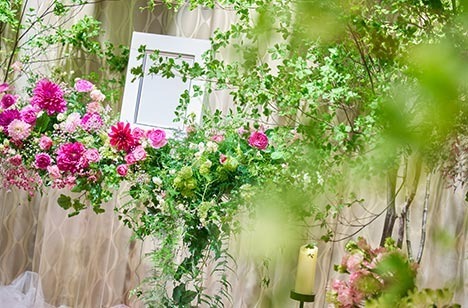 遺影写真の周りにたくさんの花が飾られています